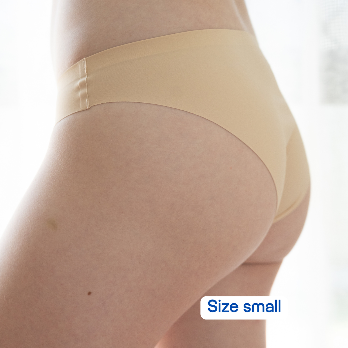 Beige underwear worn by a person on a white background with 'Size small' label.