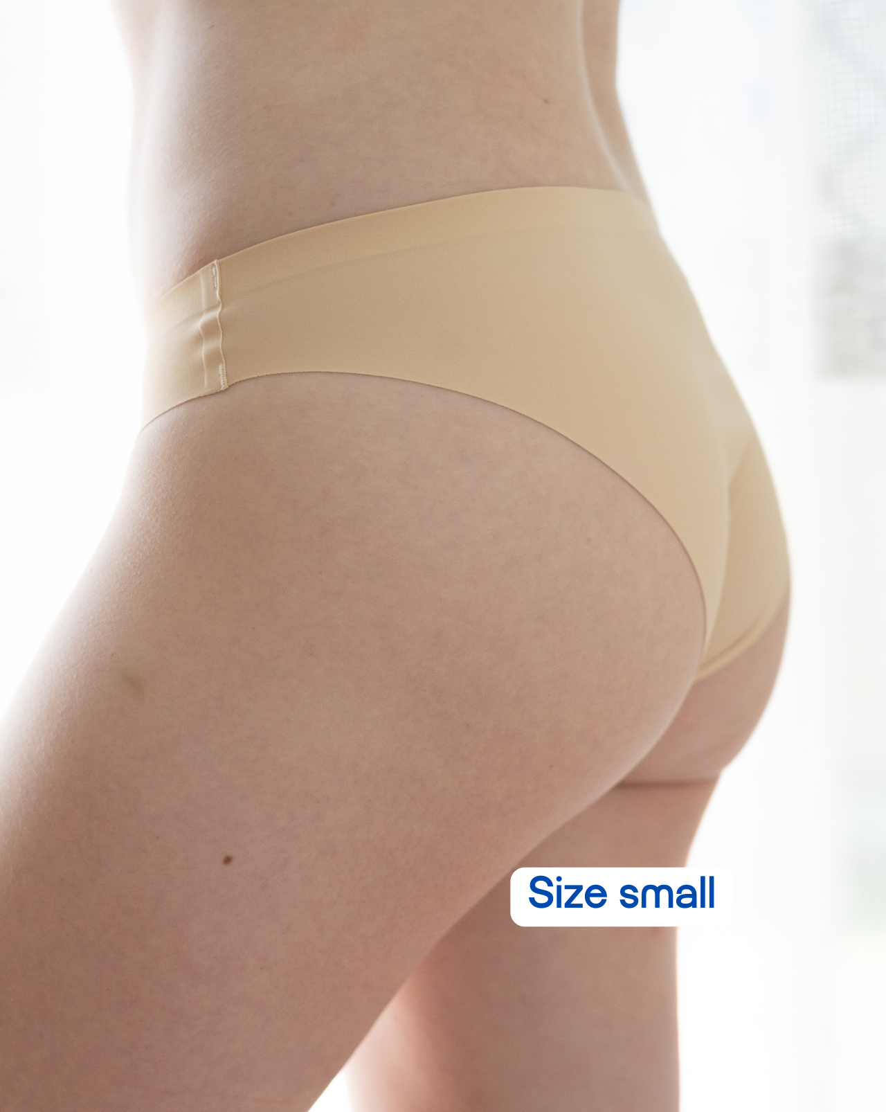 Beige underwear worn by a person on a white background with 'Size small' label.
