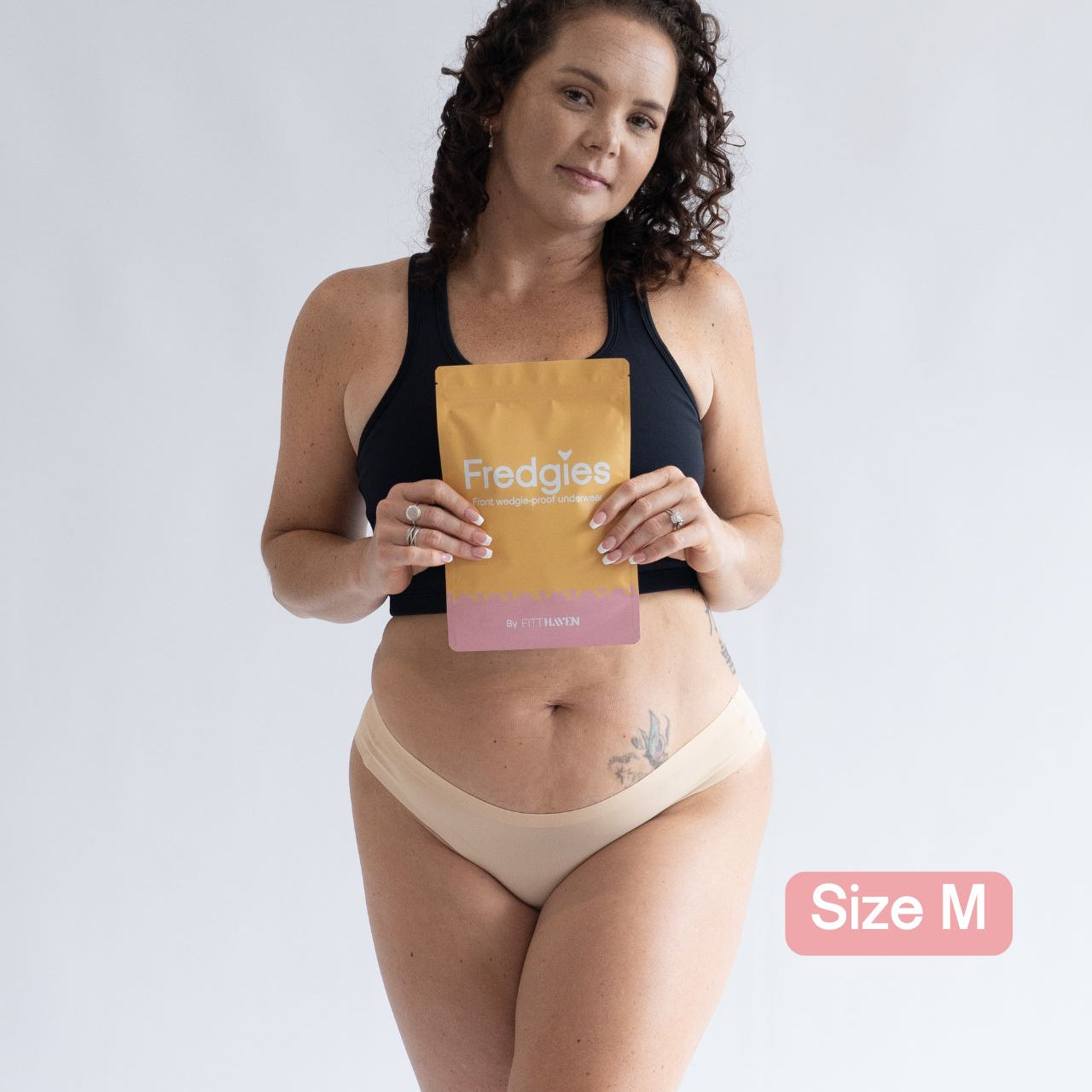Model holding Fredgies packaging whilst wearing bikini style