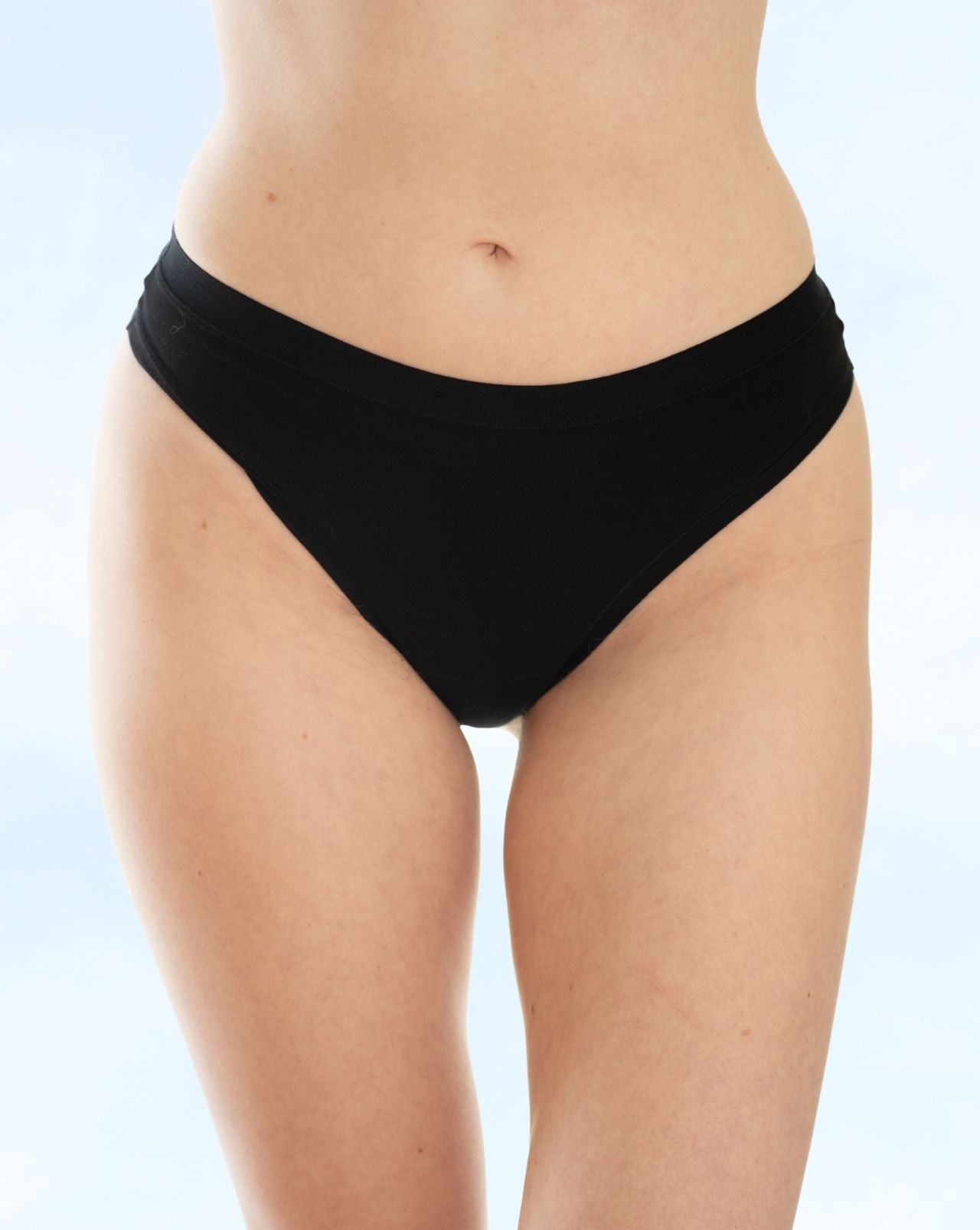 A close-up of a model wearing black underwear against a light blue background.